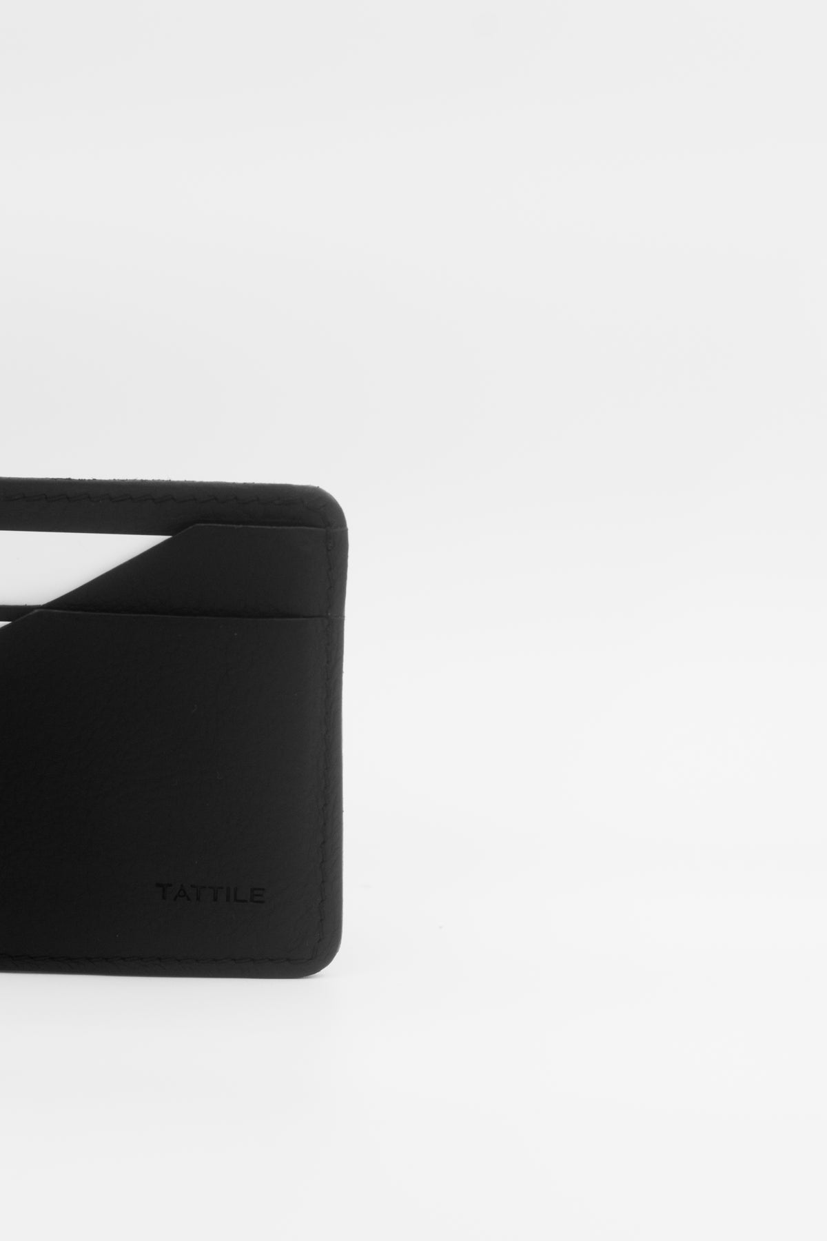 A close-up of a black minimalist card holder wallet with a debossed YATTILE logo, shown on a clean white background.